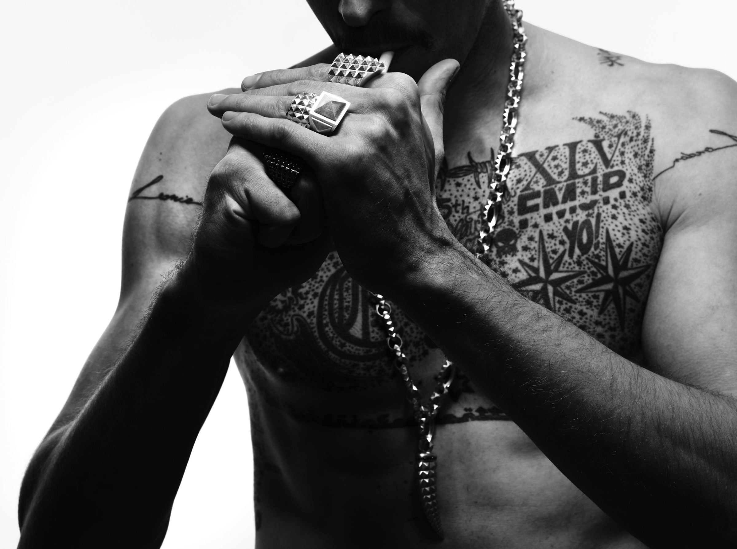 Tattooed torso with LEONY rings and chain